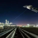 Pictures shows an illustration of a satellite connecting with a petrochemical plant